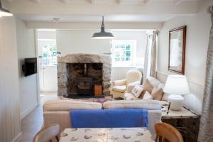 a living room with a couch and a fireplace at Otter Cottage in Pwllheli
