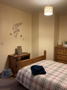 a bedroom with a bed and a laptop on a desk at Shirleys apartment in Rhyl