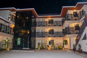 a large white building with a balcony at night at Oltotoi Suites in Lukenya