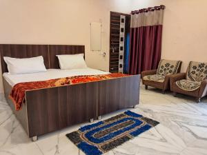 a bedroom with a large bed and two chairs at LD Guest House, Ayodhya in Ayodhya