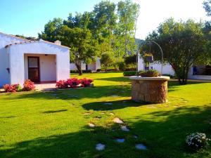 een tuin met een klein huis en een fontein bij Agriturismo Li Scopi in San Teodoro