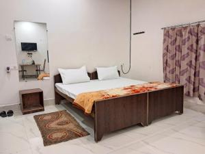 a bedroom with a bed with a wooden frame at LD Guest House, Ayodhya in Ayodhya