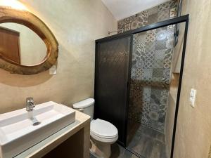 a bathroom with a toilet and a sink and a shower at Casa la Roca Valladolid in Valladolid