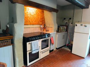 a kitchen with a stove and a refrigerator at Chez Johns in Bailleul-Neuville