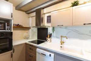 a kitchen with a sink and a stove at La Fernandiere, Historic Home, Garden and Pool in Saint-Georges-sur-Cher