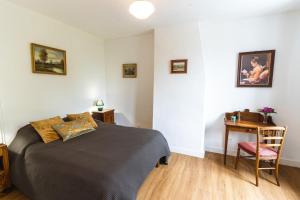 a bedroom with a bed and a table with a desk at La Fernandiere, Historic Home, Garden and Pool in Saint-Georges-sur-Cher +28 photos