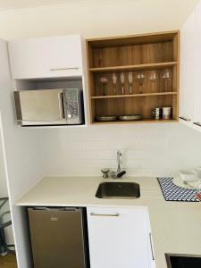 a kitchen with a sink and a microwave at Le jardin 211 in George