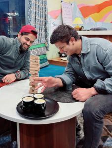 two men playing with a wooden game of dominoes at GreenDay Escapes Rishikesh in Rishīkesh