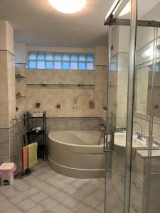 a bathroom with a tub and a shower and a sink at Casa Bianca in Pietrasanta
