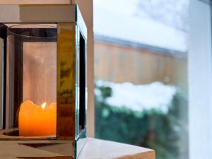a candle in a glass box on a table at Relax Ferienwohnung Roetgen in Roetgen
