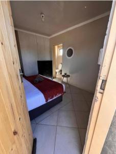 a small bedroom with a bed and a window at Begin Guesthouse in Ermelo