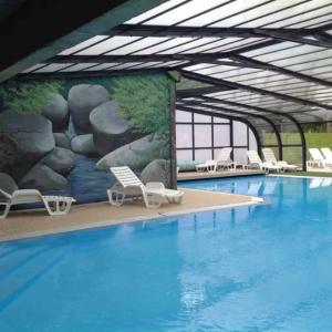 a large pool with chairs and a painting on the wall at Camping 3 étoiles - Piscine - ccafbbc in Huelgoat