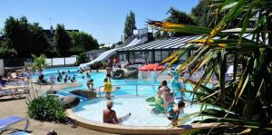 a group of people in a pool at a resort at ZEcamping 4 étoiles animé parc aquatique pet friendly sauna in Saint-Lunaire