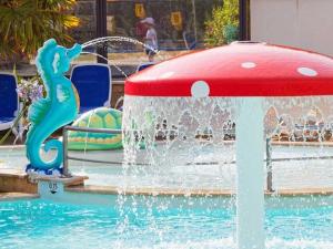 a water fountain in the middle of a pool at ZEcamping 4 étoiles animé parc aquatique pet friendly sauna in Saint-Lunaire