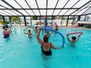 a group of people playing in a swimming pool at ZEcamping 4 étoiles animé parc aquatique pet friendly sauna in Saint-Lunaire