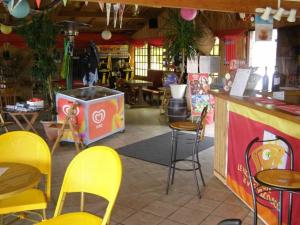 a restaurant with yellow chairs and a bar with a counter at Camping 4 étoiles - Piscine - ccafgef in La Haye-du-Puits