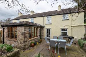 a house with a table and chairs in front of it at Charming Chepstow Cottage, 3 Bedrooms in Chepstow