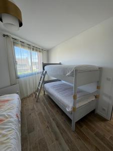 a bedroom with two bunk beds and a ladder at La maison rouge proche de Paris in Fontenay-sous-Bois