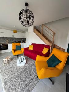 a living room with two chairs and a couch at La maison rouge proche de Paris in Fontenay-sous-Bois