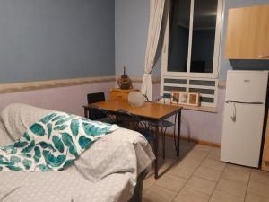 a kitchen with a table and a table and a small table and a refrigerator at Chambre au coeur de la Gaume - Chambre 3 Vert-Jaune in Virton