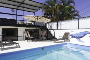 una piscina con mesa, sillas y sombrilla en JS -14B home, en Jacó