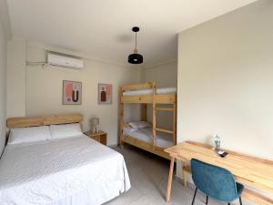 a bedroom with a bed and a desk and a bunk bed at Hotel Rimani in San Salvador