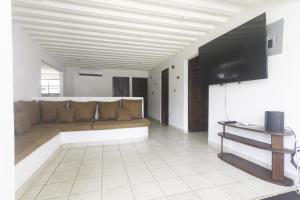 Una sala de estar con un sofá y un televisor de pantalla plana. en JS -14B home, en Jacó