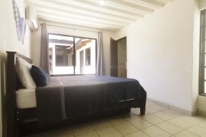 Un dormitorio con una cama grande con ventana. en JS -14B home, en Jacó 10 fotos más
