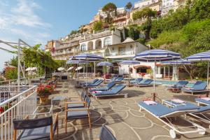 a group of lounge chairs and umbrellas on a patio at Hotel Poseidon in Positano