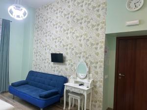 sala de estar con sofá azul y espejo en Lin Mare, en Roma 11 fotos más