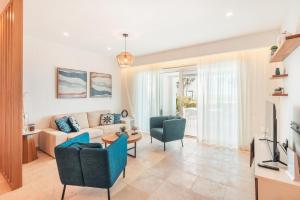 プンタ・カナにあるApartment with pool and ocean view in Punta Palmeraのソファと椅子のあるリビングルーム