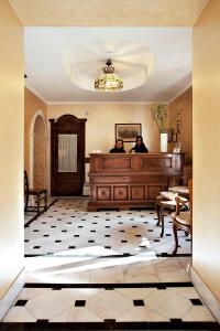2 persone in piedi in una stanza con scrivania di Hotel Arco Di Travertino a Roma