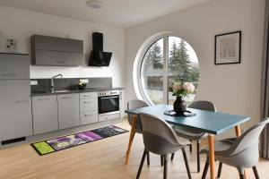 a kitchen and dining room with a table and chairs at Ferienwohnung Welfenstein in Penzing