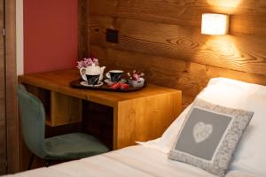 a bedroom with a table with a bed and a table with a chair at La Primula in Borgo San Dalmazzo