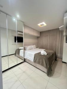 a bedroom with a bed and a glass wall at Super Premium no Bueno 3 Ares Condicionados Piscina Academia Próximo ao Hospital Albert Einstein 2408 in Goiânia