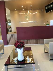 a lobby with a vase of flowers on a table at Pousada Paraiso in Guanambi