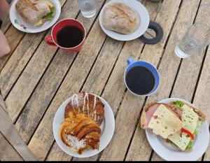 ein Tisch mit Tellern mit Essen und Tassen Kaffee in der Unterkunft Sea Breeze Cottage in Färjestaden