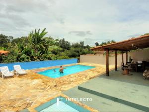 a man in a swimming pool in a house at Sítio c/ Piscina, Churrasqueira e Sala de Jogos in Caldas