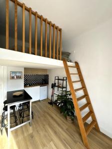 a living room with a staircase and a table at Studio Biarritz Côte des Basques in Biarritz