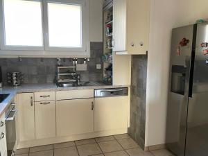 a kitchen with white cabinets and a sink at sport et repos à Leysin CH in Leysin +8 photos