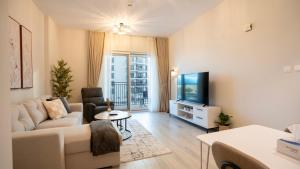 un salon avec un canapé et une télévision dans l'établissement Cozy 1br With Stunning Seaworld Views!, à Abu Dhabi