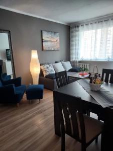 a living room with a couch and a table at Apartament Szept Plaży in Kołobrzeg
