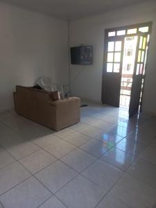Habitación con sofá y TV en el suelo de baldosa. en Casa, en Salvador