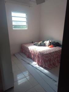 Un dormitorio con una cama en una habitación con ventana. en Casa, en Salvador