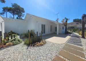 a white house with a courtyard with cactus at BRUYERES - Capbreton, belle villa spacieuse entre ville et plages au calme in Capbreton