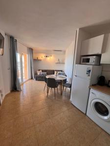 cocina y sala de estar con mesa y lavadora en Luxury La Mata, en Torrevieja