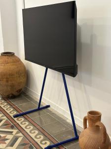a flat screen tv on a stand next to vases at Apartamento El Tozal in Teruel
