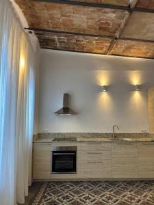a kitchen with a counter with a sink and a stove at Apartamento El Tozal in Teruel