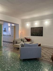 a living room with two couches and a tv on the wall at Apartamento El Tozal in Teruel +16 photos