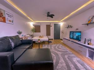 a living room with a couch and a tv at The Bachelor in Cabanatuan